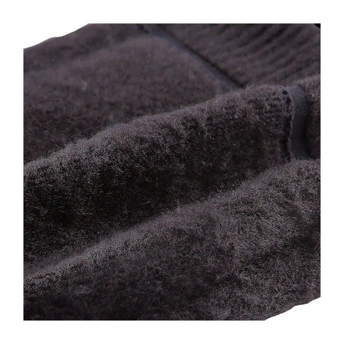 A dark, textured fabric lies in folds showcasing its soft and fuzzy surface suggesting warmth and comfort in a close-up view with no distinct background elements visible.
