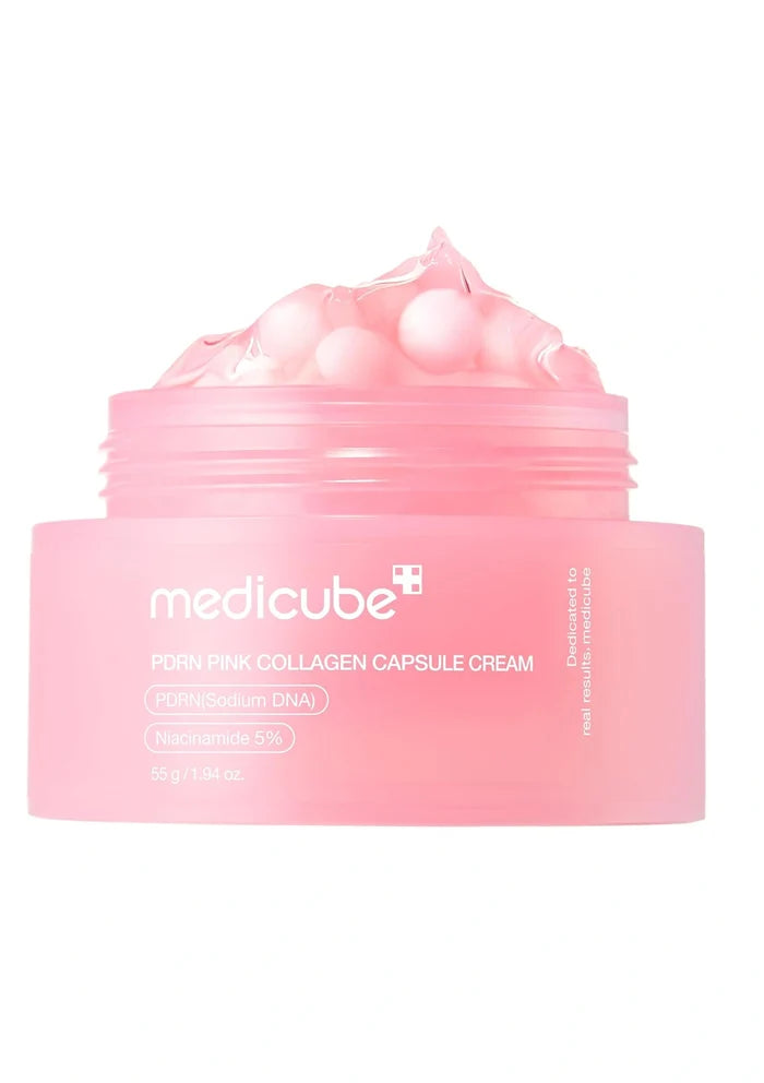 Pink container with pearl-like beads and a spoon on a white background
