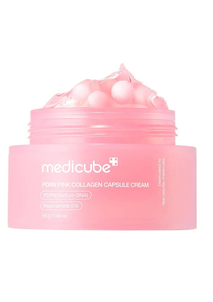 Pink container with pearl-like beads and a spoon on a white background