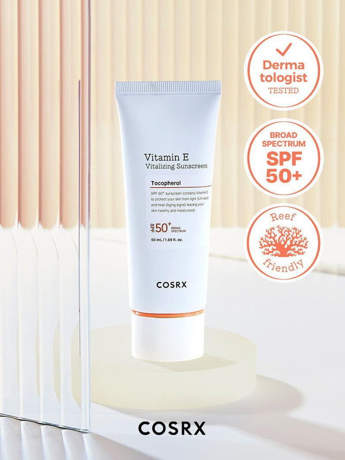 Clinically proven COSRX Vitamin E Vitalizing Sunscreen SPF 50+ in studio setting with Reef Friendly and Broad Spectrum badges; Korean UV protection formula rich in vitamin E to hydrate and brighten skin tone while remaining transparent on all skin types for daily use under makeup.